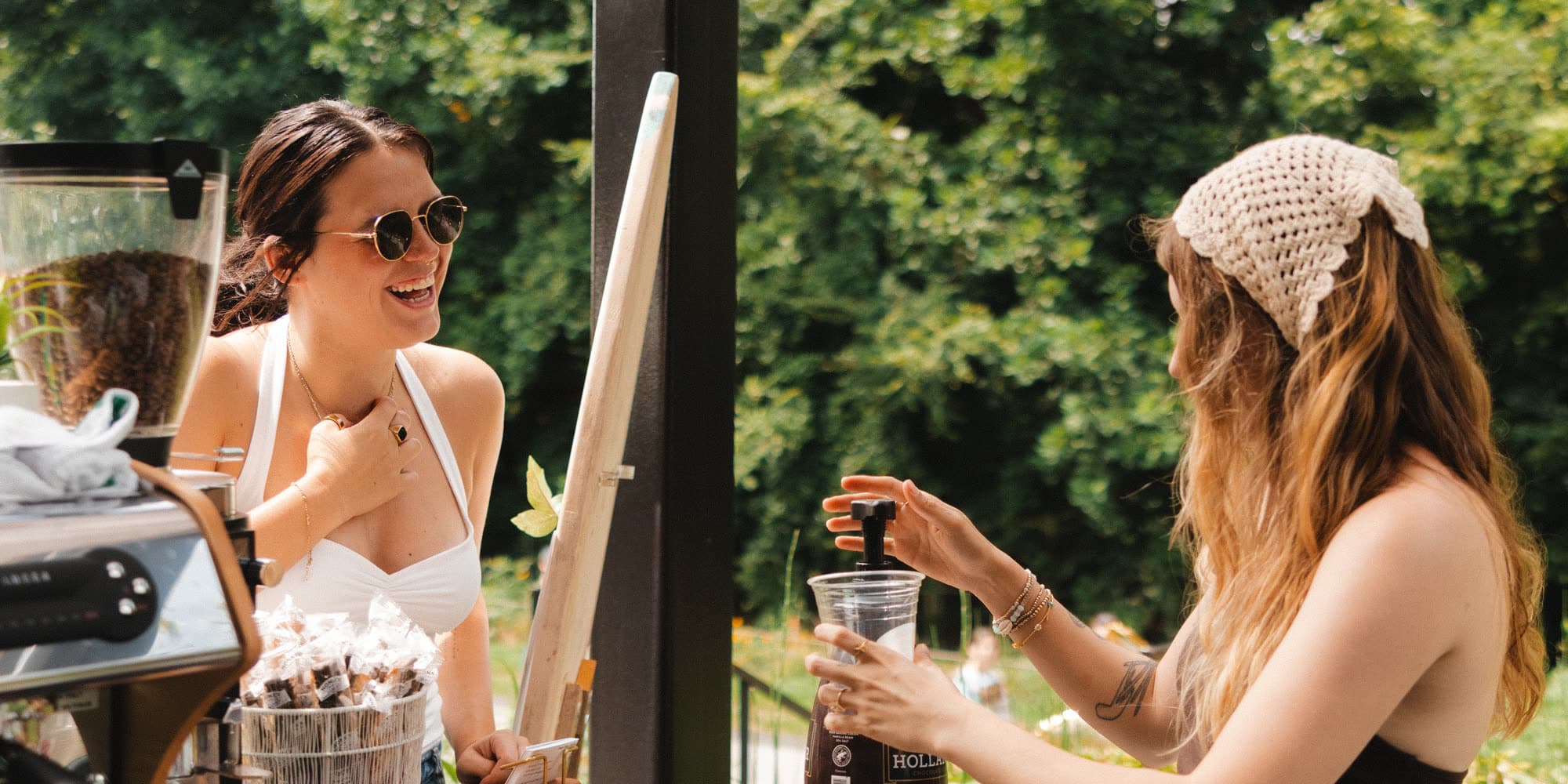 A coffee cart owner serving a customer outdoors